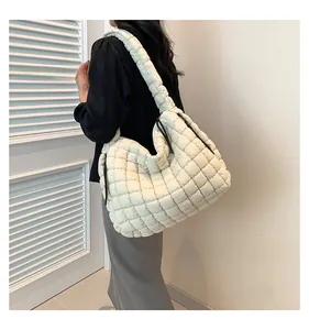 Detailed view of white quilted puffer tote bag with ruched shoulder strap and side drawstrings