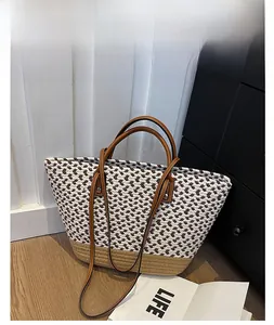 Detail view of woven tote bag showing brown leather handles and dual-tone texture