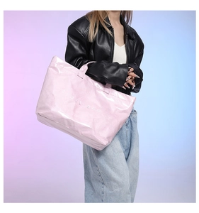 Glossy pink Tyvek tote bag featuring a reflective mirror surface and bold white text
