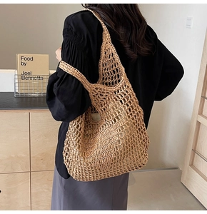 Detail of hand-woven straw mesh tote bag showing large capacity and natural texture