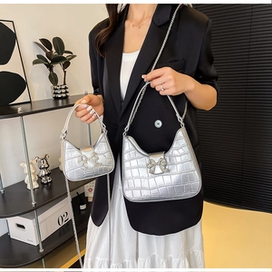 Detailed view of silver faux leather crossbody bags with rhinestone butterfly buckle