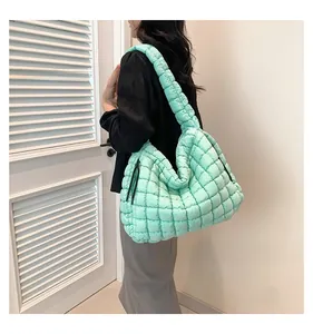 Detailed macro view of mint green quilted puffer fabric and side strap texture