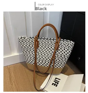 Detail of checkered woven tote bag with brown leather straps and natural straw base