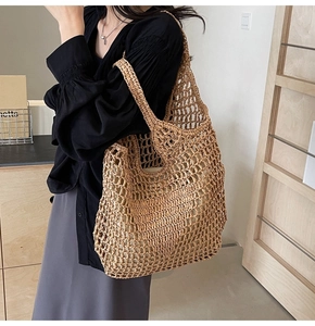 Macro view of handmade straw woven shoulder bag with hollow mesh design in natural brown