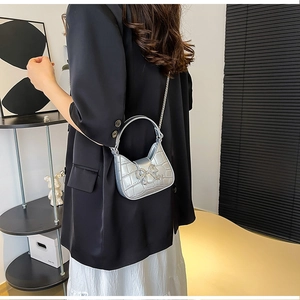 Detail of silver crocodile pattern PU leather bag with sparkling rhinestone bow and chain