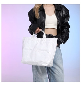 Detail shot of white Tyvek tote bag featuring a textured finish and embossed text