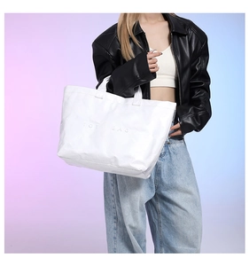 Fashionable white DuPont paper tote bag with TOTE BAG embossed design shown on model