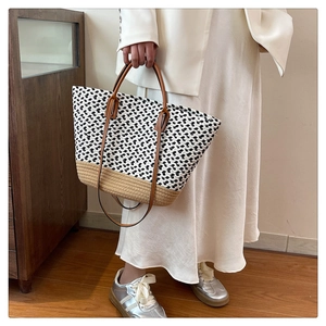 Close-up of bohemian woven tote bag with leather straps on a minimalist background