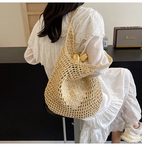 Detail view of woven straw tote bag with large hollow mesh design for summer vacation