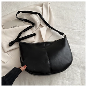 Minimalist black PU leather half-moon hobo bag with sleek zipper and decorative stitching