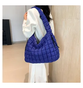 Detail of bright blue quilted puffer tote bag with side drawstrings and large capacity