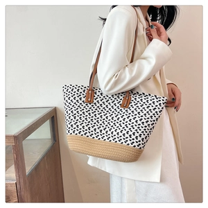 Detail of bohemian large capacity woven tote bag with contrast colors and leather straps