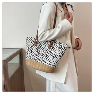 Detail of bohemian woven tote bag with two-tone texture and leather shoulder straps