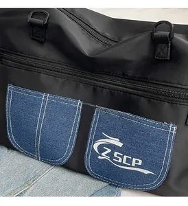Detail of black nylon fabric with blue denim pocket and white ZSCP logo on crossbody bag
