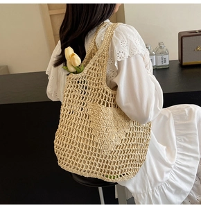 Detail of hand-woven beige cotton mesh tote bag carried by a model in a cafe setting