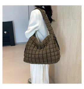 Model view of large olive brown quilted tote bag with square puff texture and wide strap