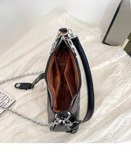 Vista dall'alto dell'interno della borsa in PU nero con fodera marrone e scomparti zip