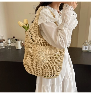 Detailed close-up showing the hand-woven texture and hollow mesh design of the beige straw tote