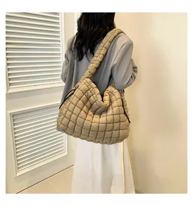 Detailed back view of a beige quilted puffer tote bag with thick shoulder straps