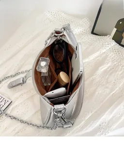 Vista interna della spaziosa borsa argento con catena che mostra lo spazio per oggetti