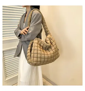 Detail of the khaki quilted puffer tote bag showing square stitching and wide shoulder strap