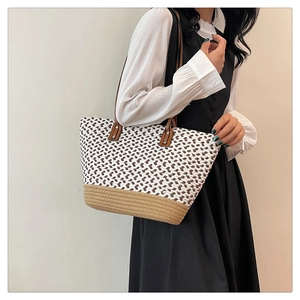 Close-up of bohemian woven tote bag with geometric patterns and brown leather straps