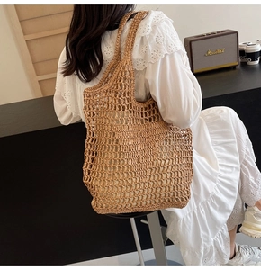 Lifestyle view of a hand-woven straw tote bag with a mesh hollow pattern and vintage vibe
