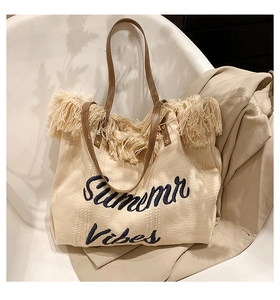Détail du sac cabas tissé beige avec franges et broderie bleue Summer Vibes