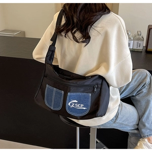Detail of crossbody bag with denim patchwork pockets and Z SCP logo on model