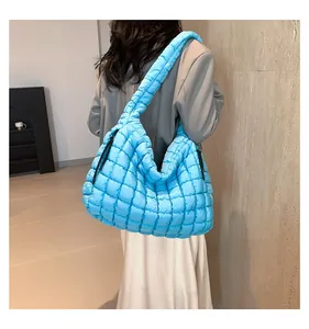 Macro detail of the sky blue quilted puffer tote bag with black drawstring side ties