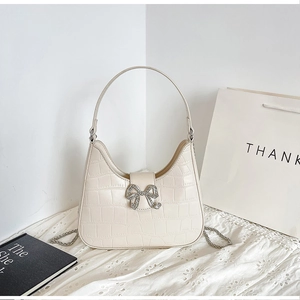 Chic cream PU leather hobo bag with crocodile pattern and a sparkly rhinestone bow charm