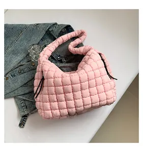 Detail view of the pink quilted puffer tote bag with side drawstring and shoulder strap
