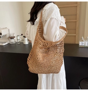 Detail of handmade woven straw tote bag featuring hollow mesh texture for summer