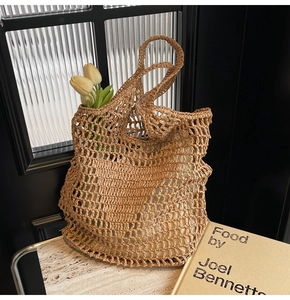 Close-up of handmade straw woven bag with intricate mesh pattern and cotton rope handles