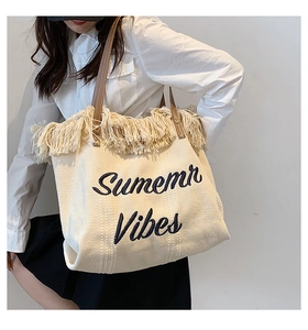 Détail de la broderie Summer Vibes et des franges sur un sac fourre-tout en toile tissée
