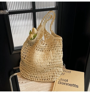 Close-up of cream woven mesh handbag featuring intricate knit texture and long handles
