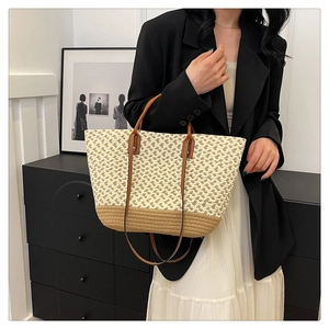 Detail view of the bohemian woven tote bag showing its two-tone straw and leather handles