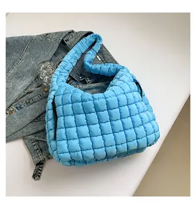 Detail of bright blue quilted cloud bag showing square stitching and nylon texture
