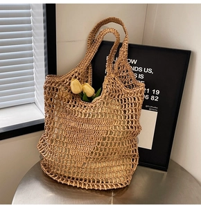 Detail of hand-woven straw tote with hollow mesh pattern and yellow tulip flowers