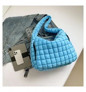 Close-up of quilted puff cloud bag in bright blue with thick padded shoulder strap