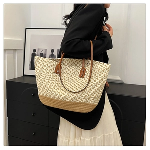 Detail of bohemian woven tote bag with two-tone design and brown leather straps