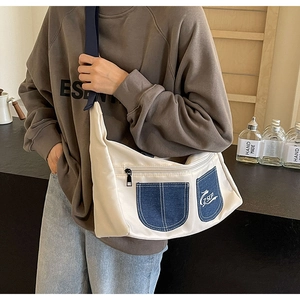 Close-up of beige canvas crossbody bag with blue denim pockets and ZSCP logo detail