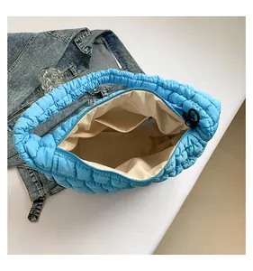 Macro view of bright blue quilted tote bag showing interior lining and zipped pocket