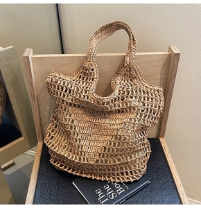 Detailed view of handmade woven straw tote bag with large hollow mesh net pattern design