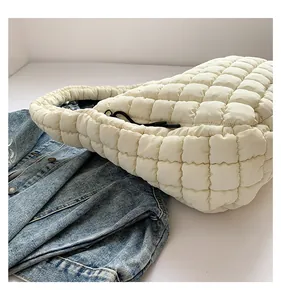 Detail view of white quilted puffer tote bag with soft texture and black drawstring accents