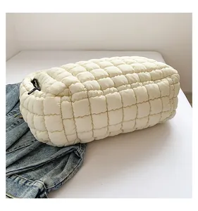 Detail shot of the cream quilted cloud bag with padded texture and black zipper pull