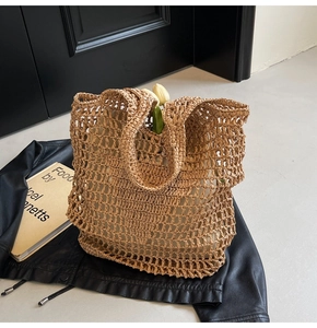 Detailed close-up of handmade hollow straw tote bag featuring woven mesh texture and straps