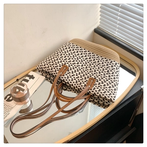 Detail of woven straw bag texture with leather handle on decorative mirror tray