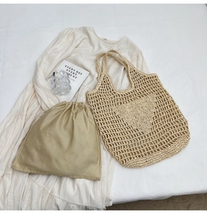 Detail of hollow mesh woven tote bag featuring a heart pattern and drawstring inner pouch