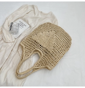 Close-up of beige woven straw tote bag featuring a hollow mesh design and soft texture